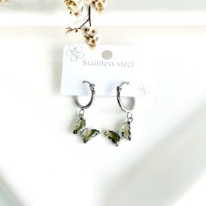 Aros de acero, argolla, dije de mariposa con piedras marrónes.