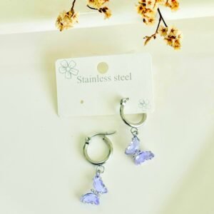 Aros de acero, argolla, dije de mariposa con piedras lilas.