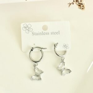Aros de acero, argollas, dije de mariposas con piedras blancas.