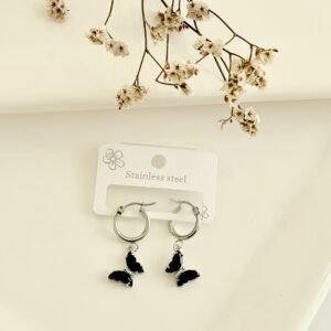 Aros de acero, argollas, dije de mariposas con piedras negras.