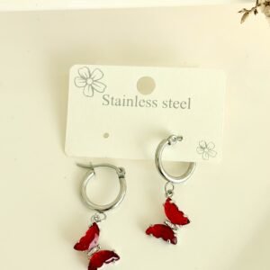 Aros de acero, argollas, dijes de mariposas con piedras rojas.