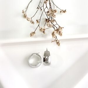 Aros de acero anchos con flores labradas. 2 cm. de diámetro.