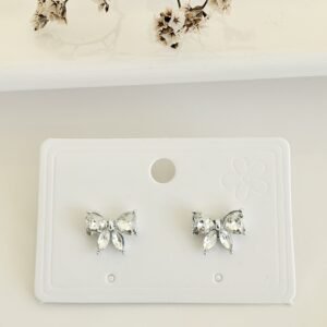 Aros pasantes, moño con piedras blancas.