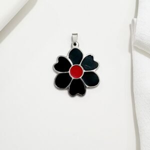 Dije en forma de flor. Pétalos negros, y un delicado centro rojo.