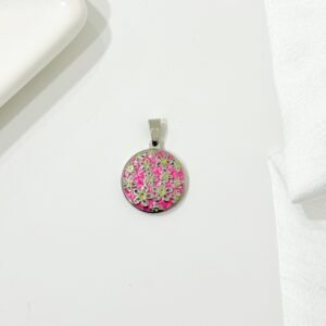 Dije redondo, flores sobre esmalte color rosa. Chico.