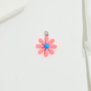 Dije flor rosada, centro celeste. Fabricado en material plástico.