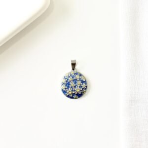 Dije redondo, flores sobre esmalte azul. Chico.