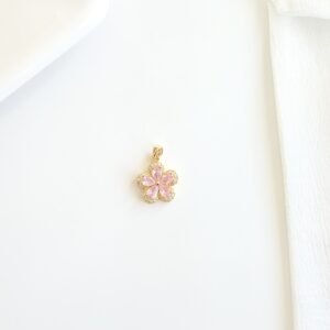 Dije dorado piedras rosadas.