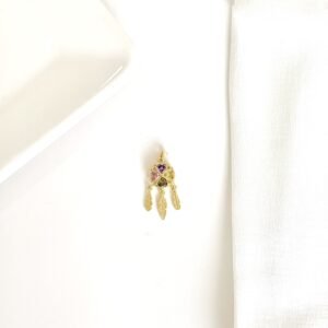 Dije atrapasueños dorado con piedras de colores.