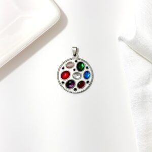 Dije de acero quirúrgico blanco con piedras de colores.