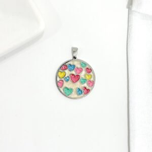 Dije de acero, esmaltado con corazones de colores.