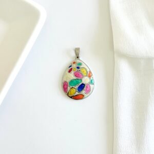 Dije en forma de gota, esmalte blanco con flores de colores.