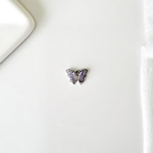 Dije de mariposas con piedras lilas.