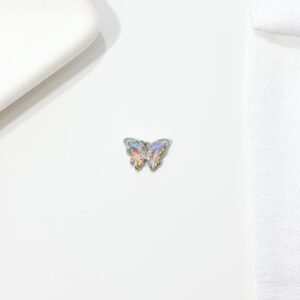Dije de mariposa con piedras blancas.