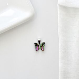 Dije de mariposa con piedras tornasol y strass.