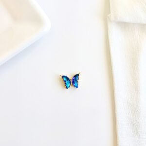 Dije de mariposa dorado con piedras y strass.