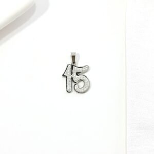 Dije 15 años. Acero con strass.