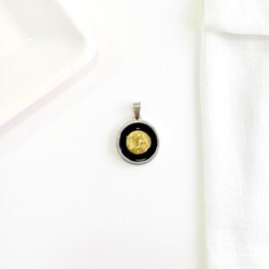 Dije San Benito, esmalte negro y centro dorado.