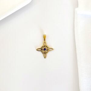 Dije nudo de bruja dorado con piedra azul.