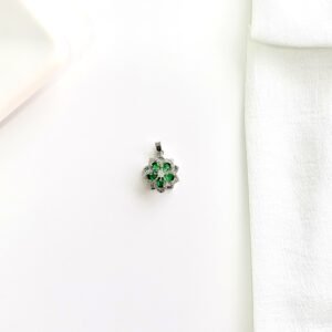 Dije giratorio con piedras verdes.