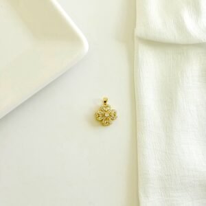 Dije giratorio dorado con piedras y strass.