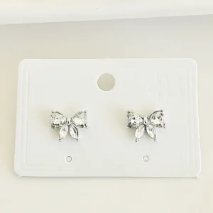 Aros pasantes, moños con piedras blancas.