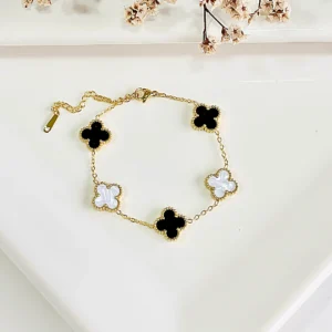 Pulsera de acero dorado, treboles blancos y negros.