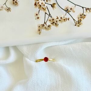 Anillo acero dorado con piedra roja.