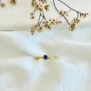 Anillo acero dorado con piedra lila.