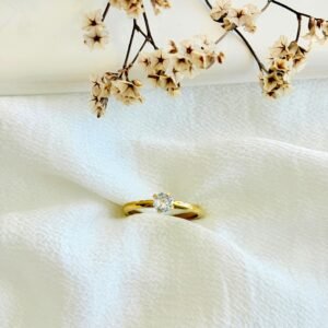 Anillo acero dorado con piedra blanca.