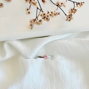 Anillo acero con piedra rosa.