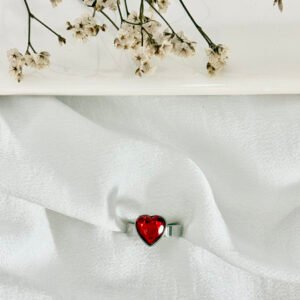 Anillo de acero, corazón con piedra roja.