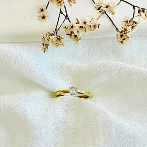 Anillo acero dorado con piedra blanca.