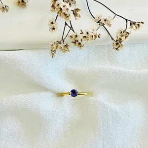 Anillo acero dorado con piedra lila.