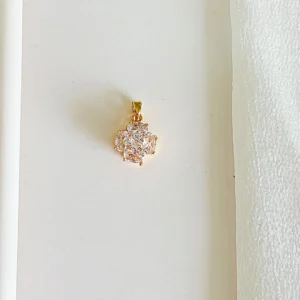 Dije de acero dorado con piedras, giratorio.