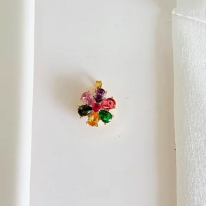 Dije de acero dorado con piedras de colores, giratorio.